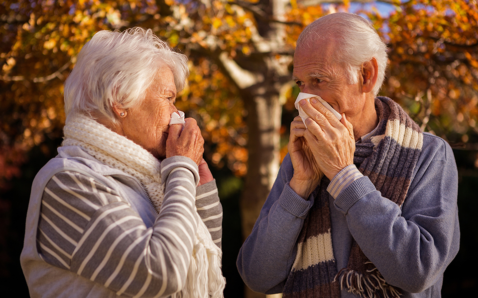 Older couple blowing their noses