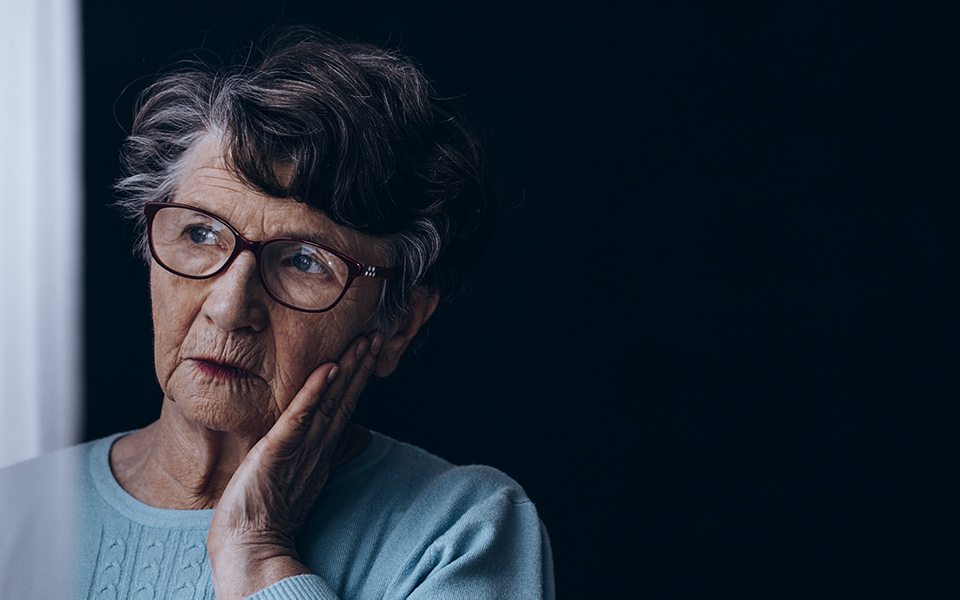 Image of older woman looking upset out of the window