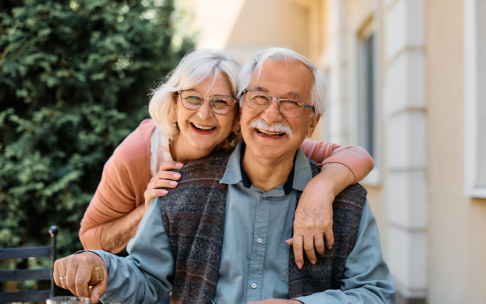 Happy senior couple at independent living community looking at camera