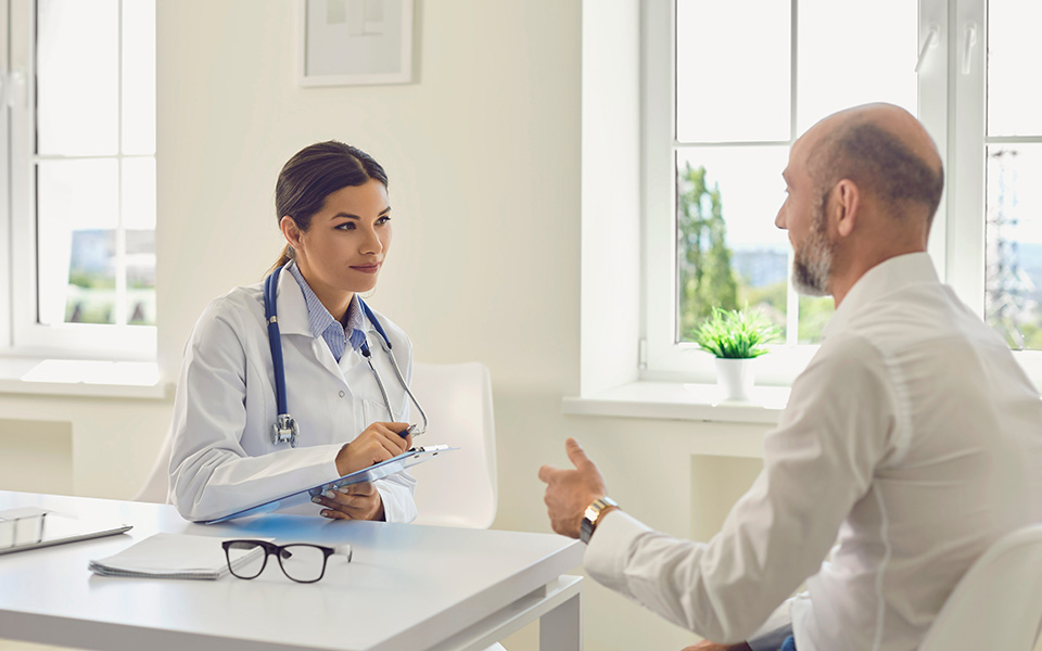 Male patient pensioner speaks with the doctor