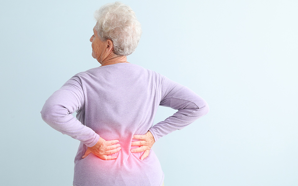 Elderly woman holding back in pain