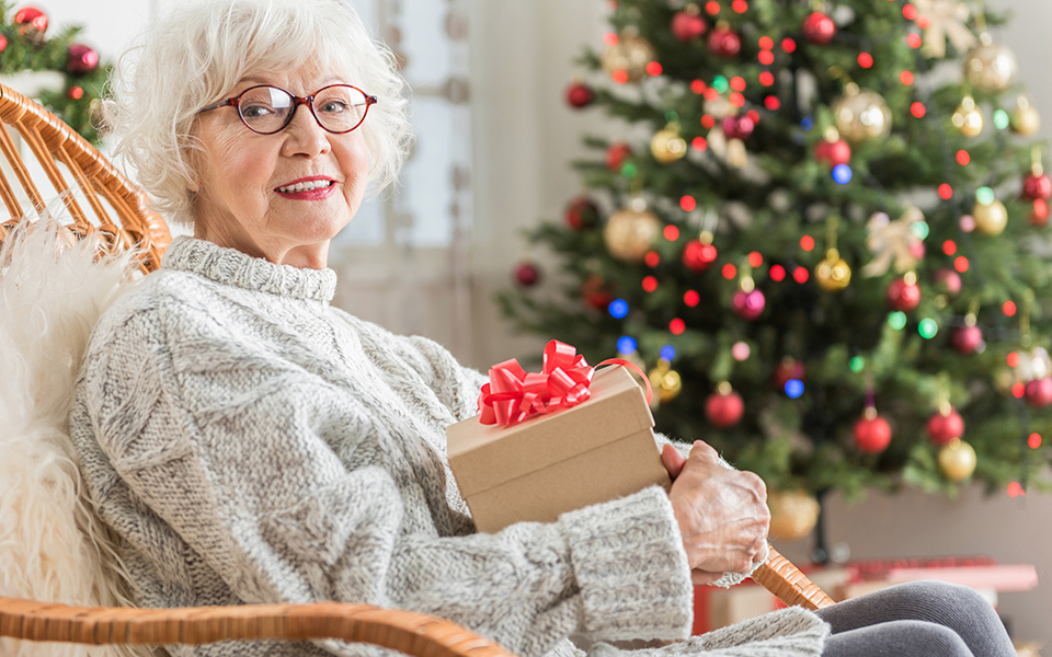 Senior sitting with gift on lap