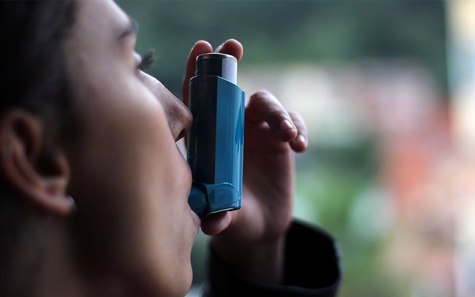 Woman using an blue inhaler