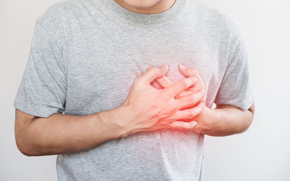 A man touching his heart, with red highlight of heart attack or other forms of heart disease concept