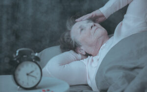Senior woman with dementia laying in bed at night