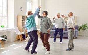 Happy retired senior people having a party, dancing and having fun together